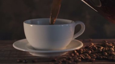 Ahşap masa üzerinde kahve çekirdekleri ile sıcak kahve