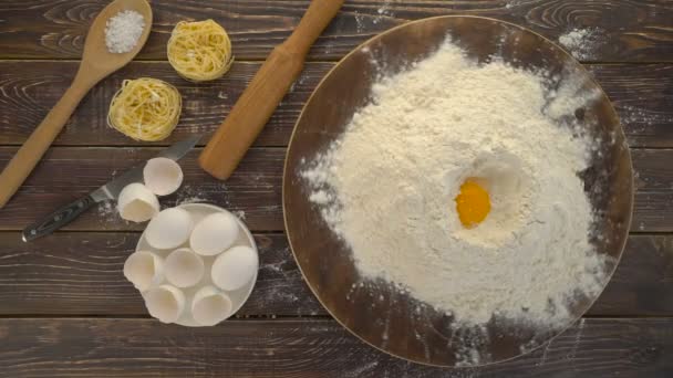 Punhado de farinha com gema de ovo em um fundo de madeira escura — Vídeo de Stock