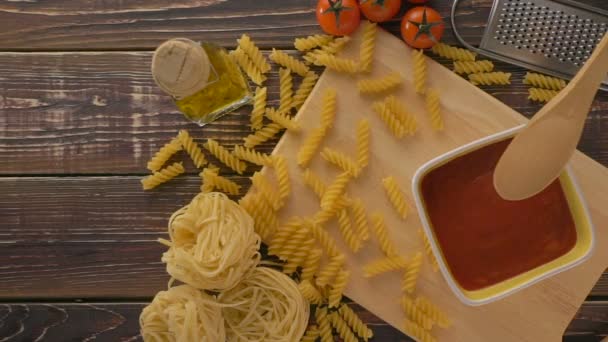 Pasta en ingrediënten op de houten tafel — Stockvideo