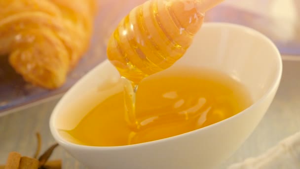 Med s dřevěnými medu naběračka a keramická mísa — Stock video