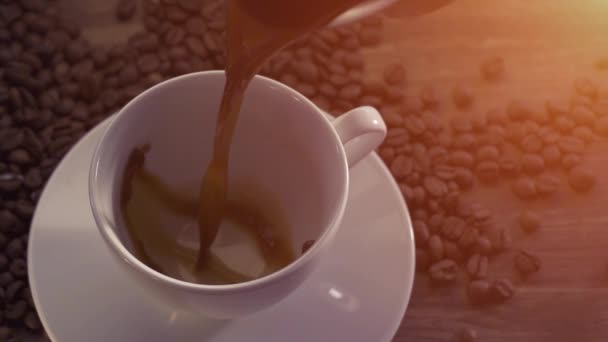 Gieten van koffie, omringd door koffie bonen — Stockvideo