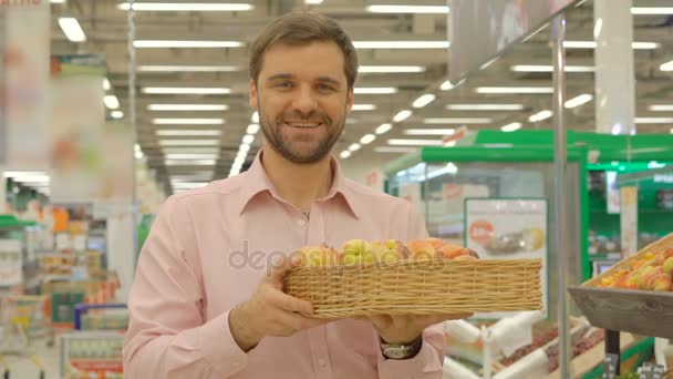 Hombre feliz sosteniendo cesta con albaricoques y sonriendo — Vídeos de Stock