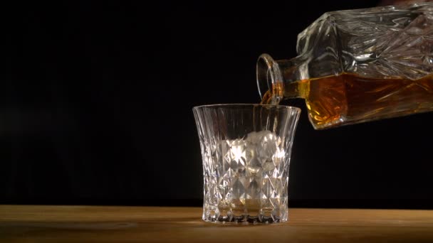 Whisky s ledem sype z láhve - alkohol, bar whisky nalil do sklenice s ledem — Stock video