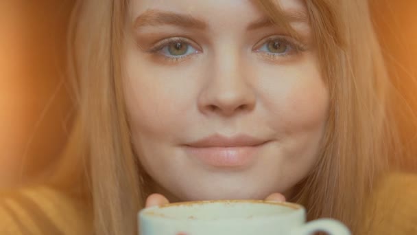 Mosolygó aranyos nő forró kávét kezében tartja. Belélegzése aroma és relaxáló — Stock videók