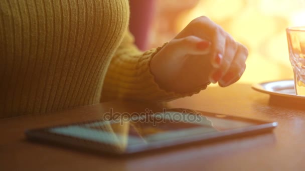 Menina usando tablet no café. Fundo desfocado com efeitos de erupção da lente . — Vídeo de Stock