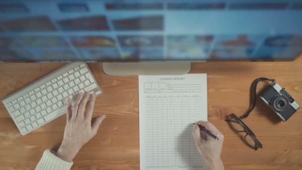 Fotograaf met behulp van beeldscherm en toetsenbord te selecteren van foto's van computerscherm. Bovenaanzicht — Stockvideo