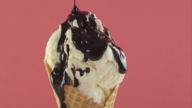 Dondurma waffle koni pembe bir arka plan üzerine çikolata sos ile