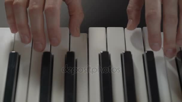 Hands of a woman playing the piano on black background, top view, closeup — Stock Video