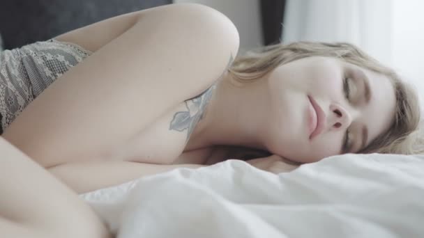 Όμορφο κορίτσι ξαπλωμένο στο υπνοδωμάτιο στο νωρίς το πρωί , — Αρχείο Βίντεο