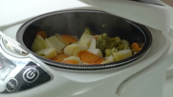 Варить вареные овощи в электрической плите дома — стоковое видео
