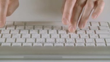 Beyaz zemin üzerinde bir klavye yazarak eller