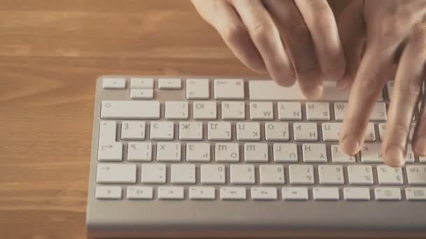Manos femeninas escribiendo en un teclado sobre fondo de madera — Vídeos de Stock