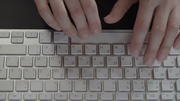 Erkek yazarak metin üstünde belgili tanımlık klavye, üstten görünüm eller. — Stok video