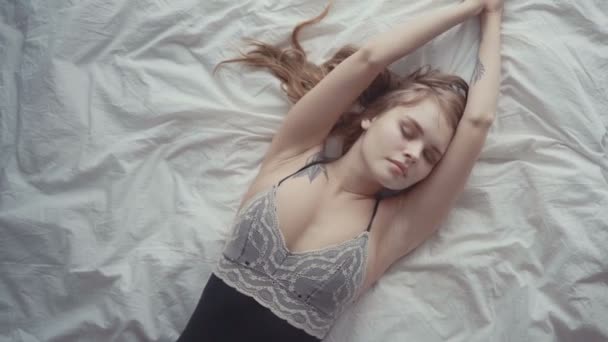 Vista superior de la hermosa mujer joven en ropa interior negra durmiendo en la cama en casa — Vídeo de stock