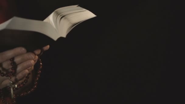 Kristen kvinna läsa Bibeln på svart bakgrund — Stockvideo