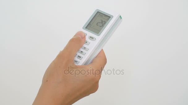 Female hand pushing temperature button on air conditioner remote control — Stock Video
