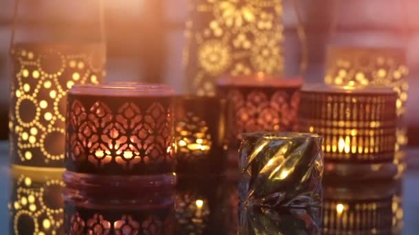 Variety of candles lights with reflection on a glass table in evening — Stock Video