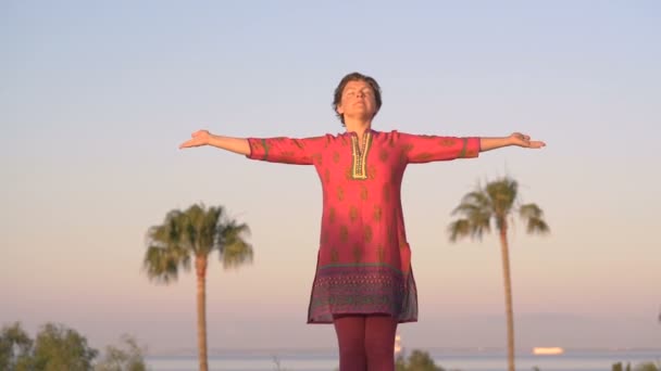 Женщина практикует йогу на открытом воздухе во время утренней медитации.Мирная медитация в утренний солнечный день для хорошего здоровья. — стоковое видео