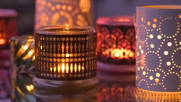 Разнообразие свечей с отражениями на стеклянном столе — стоковое видео