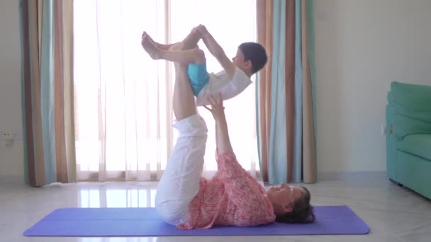 Mãe faz fitness com seu menino em casa . — Vídeo de Stock