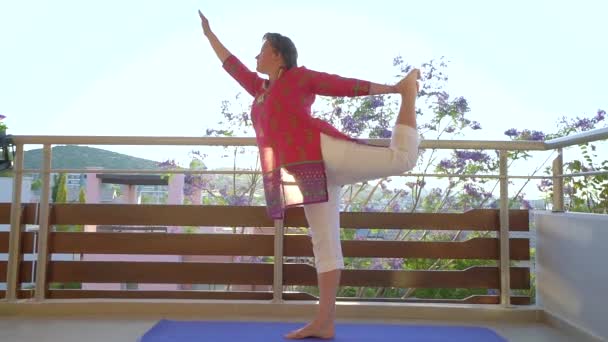 Kobieta robi joga asana na tarasie w godzinach porannych — Wideo stockowe
