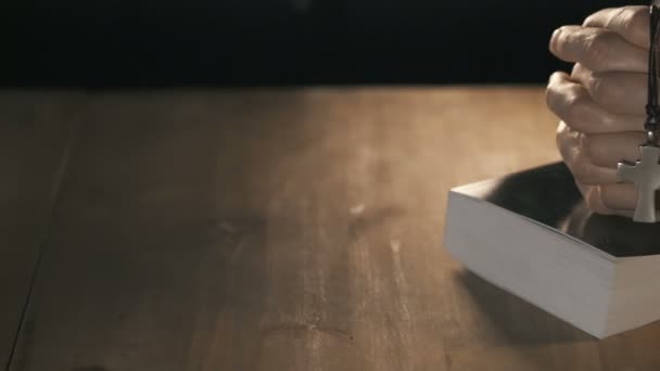 Femme priant avec sa bible sur une table en bois 