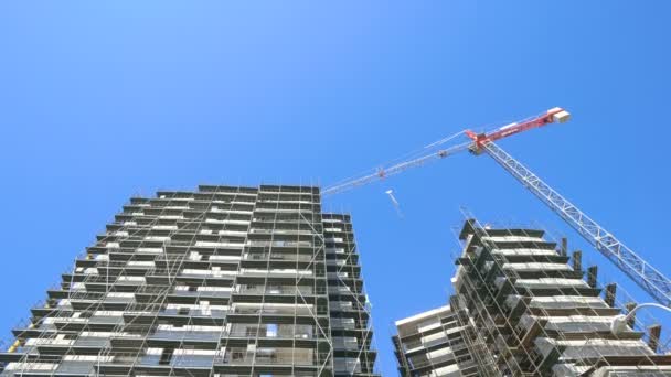 High-rise building construction site with cranes against blue sky — Stock Video