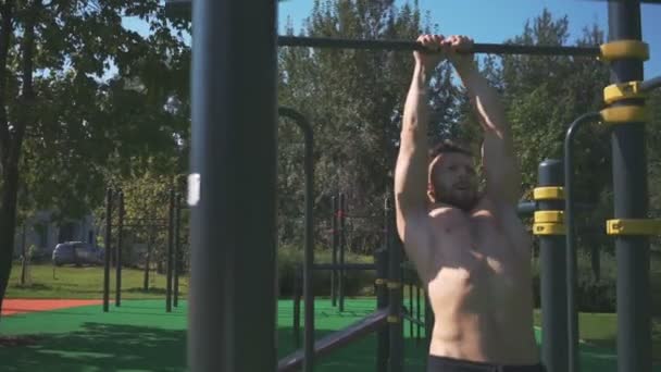 Atleta muscular haciendo ejercicio en un gimnasio al aire libre — Vídeos de Stock