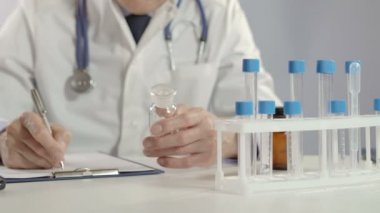 Erkek doktor hap ve yazma reçete worktable, kavanoz holding