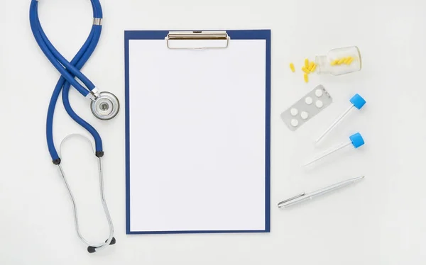 Mesa de médico com medicamentos, estetoscópio e óculos, vista superior — Fotografia de Stock