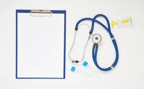 Mesa de médico com medicamentos, estetoscópio e área de transferência, vista superior — Fotografia de Stock