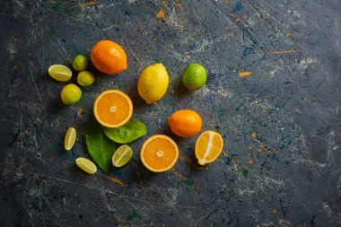 Koyu arkaplanda taze sitruslar. Portakal ve limon. Üst görünüm