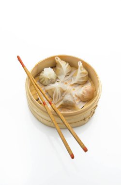 Dim, beyaz arka planda çubukları olan bambu buharlı bir tencerede toplanır.