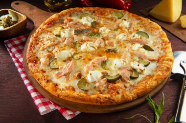 Ahşap zemin üzerinde somon ve peynirli pizza.