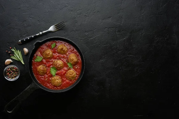 Cozinhar almôndegas com molho de tomate em panela preta. Flat lay, vista superior com espaço de cópia — Fotografia de Stock