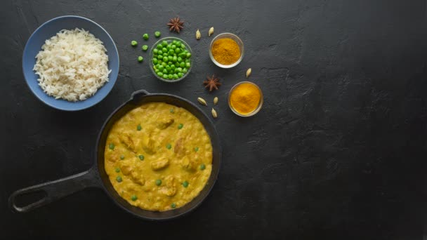 Cinemagraph loop. Cooking tasty chicken curry dish with rice in a cast iron pan — Stock Video