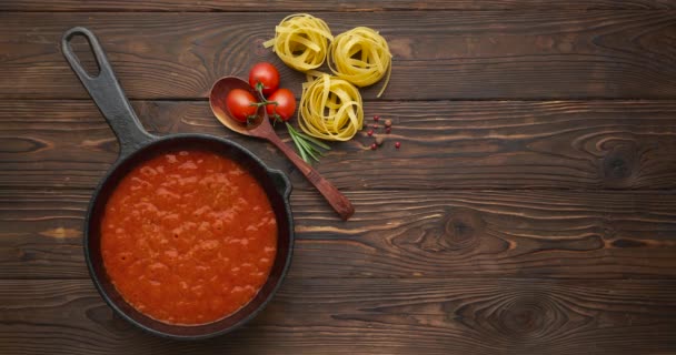 Laço de cinematografia. Molho de tomate quente borbulhante de massa, cozinhando em uma panela na mesa de madeira — Vídeo de Stock