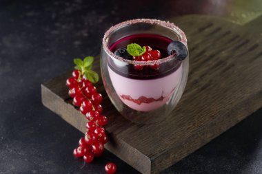 Kırsal ahşap arka planda bir bardak panna cotta tatlısı.