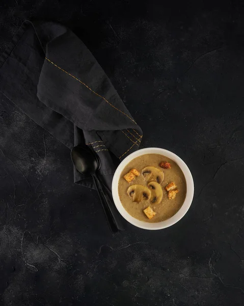 Sopa de champiñones en tazón blanco con croutons sobre fondo oscuro. Vista superior con espacio de copia — Foto de Stock