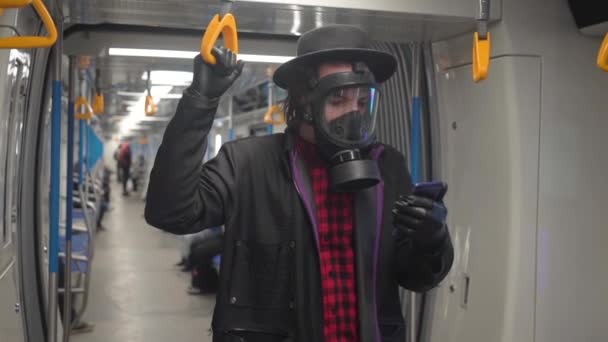 Jonge man met gasmasker en zwarte medische handschoenen tegen coronavirus covid-19, millenial hipster boy met zwarte hoed die beschermt tegen infectie van virussen, pandemie en epidemie van ziekten in de metro — Stockvideo