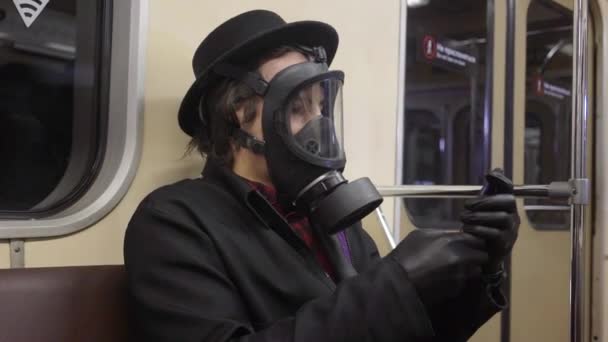 Ung man bär gasmask och svarta medicinska handskar mot coronavirus covid-19, millenial hipster pojke i svart hatt som skyddar mot infektion av virus, pandemi och epidemi av sjukdom i tunnelbanan — Stockvideo