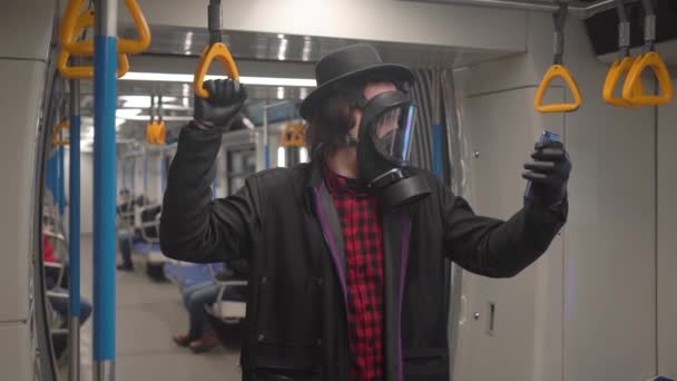 Jonge man met gasmasker en zwarte medische handschoenen tegen coronavirus covid-19, millenial hipster boy met zwarte hoed die beschermt tegen infectie van virussen, pandemie en epidemie van ziekten in de metro — Stockvideo