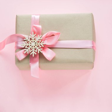 Noel hediye kutusu pembe kurdele ve pembe üzerinde kar taneleri olan kız için. Kare görüntü.