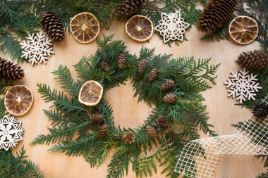 Noel tatili için hazırlık. Noel çelenk, dekor, Kuru portakal, dal ve kar taneleri bileşimi. Kadın bir çelengi hazırlamak. En iyi görünüm ve kopya alanı. Düz yatıyordu.