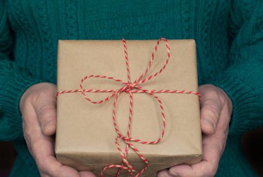 El mans Noel ve yeni yıl hediye kutu kırmızı kurdele ile beyaz kazak tutun.