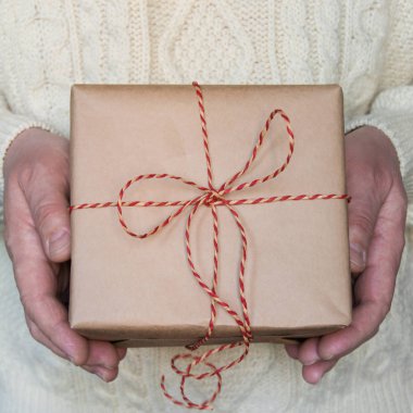 El mans Noel ve yeni yıl hediye kutu kırmızı kurdele ile beyaz kazak tutun.