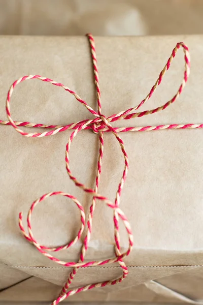 Weihnachts- oder Neujahrsgeschenkbox mit roter Schleife aus Bastelpapier. Nahaufnahme. — Stockfoto