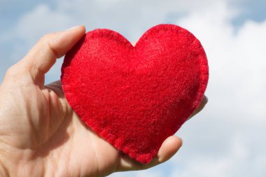 Kırmızı mavi gökyüzü bulutlu yandan kalp şeklinde arka plan olarak hissettim. Sevgililer günü tebrik kartı.