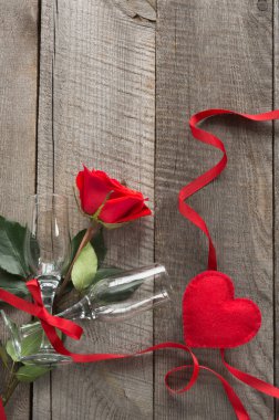 Sevgililer kartı. Kırmızı gül ve ahşap tahta üzerinde iki bardağı. Üstten Görünüm.