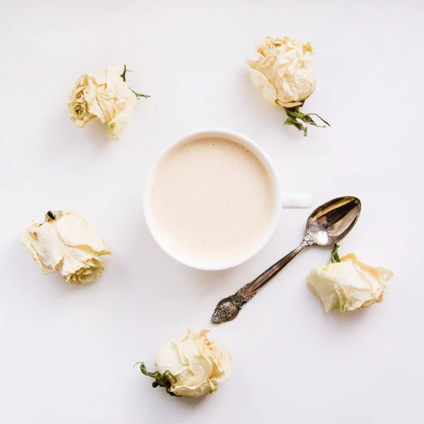 Natureza morta de uma xícara de café ou cappuccino com rosas brancas secas em volta. Quadrado. Isolado. Tonificado . — Fotografia de Stock